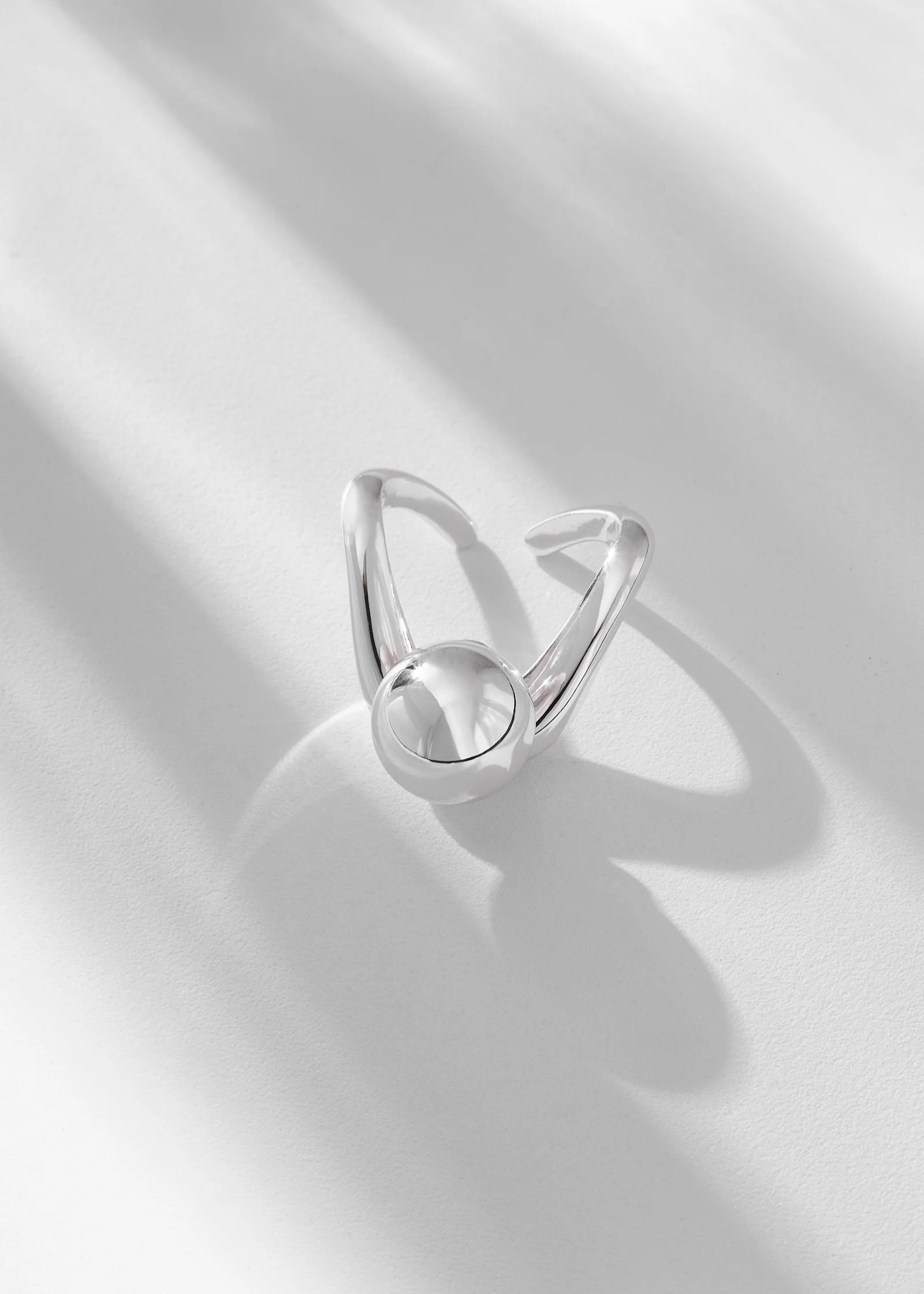Silver ring with a unique design on a light gray background