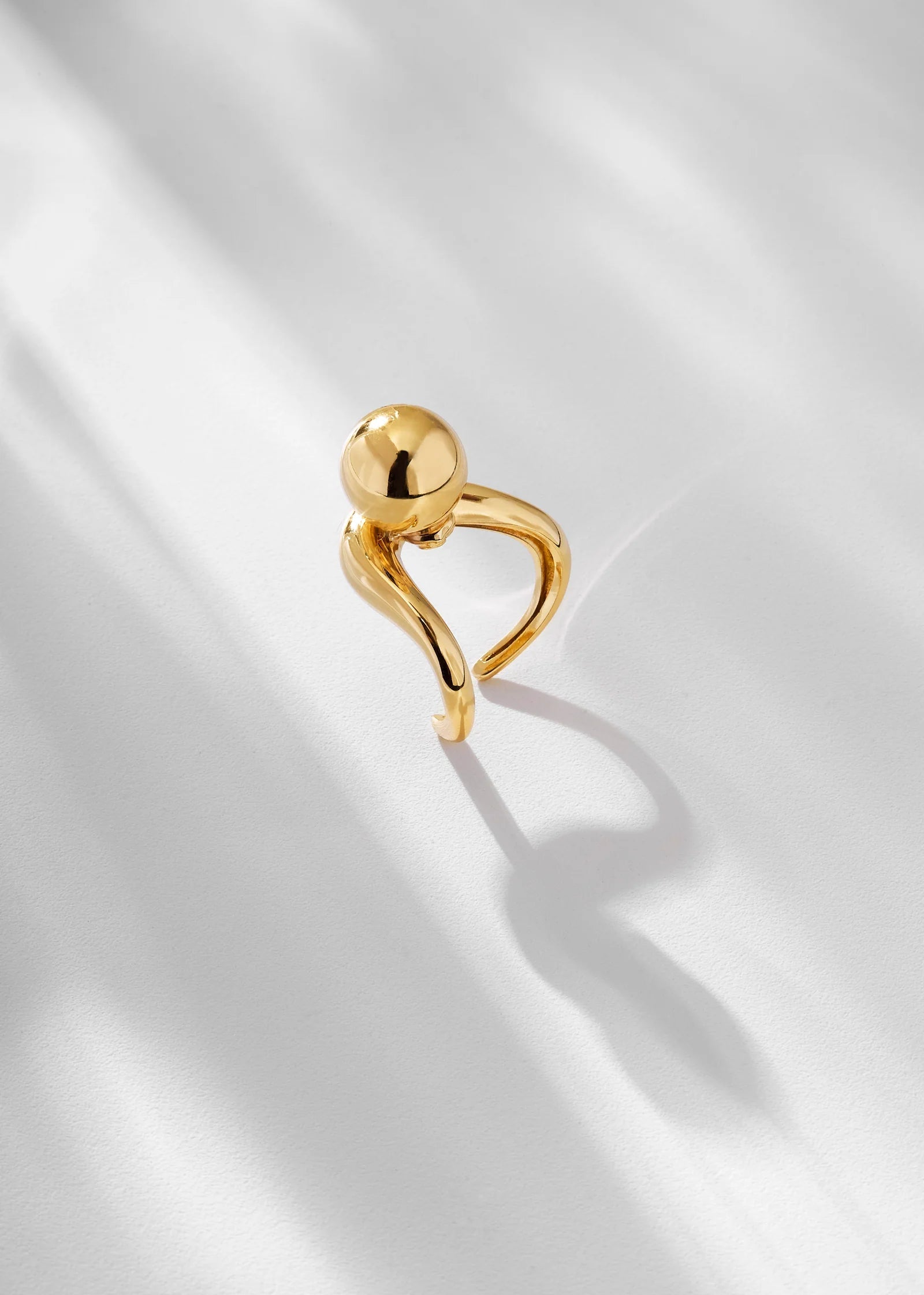 Gold ring with a unique design on a light background
