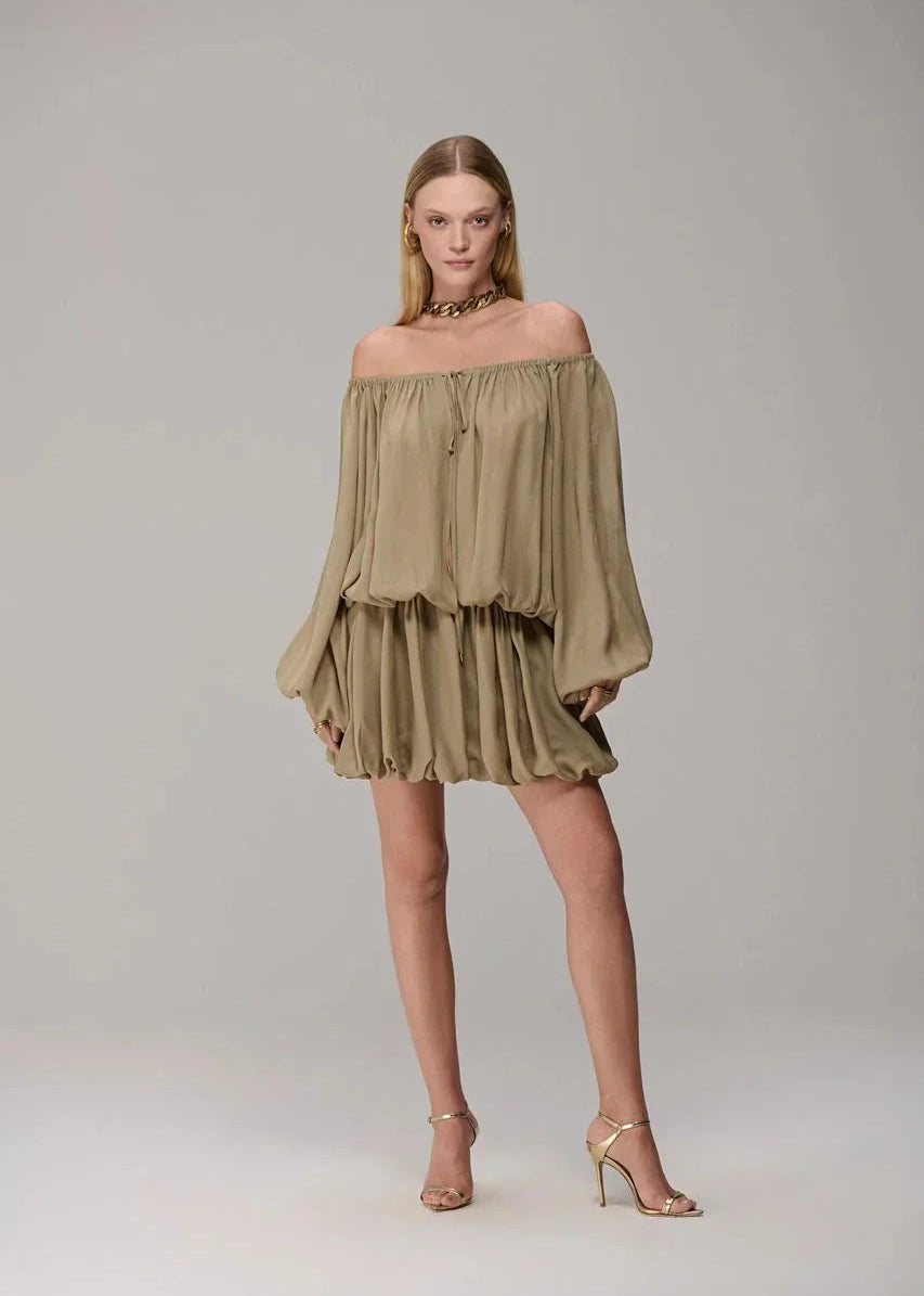 Woman wearing a green off-shoulder dress on a gray background
