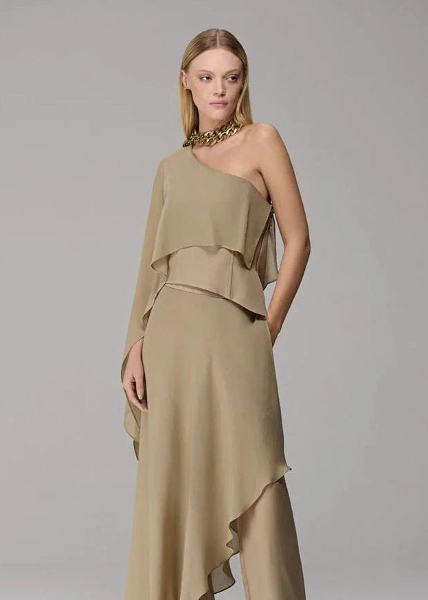 Woman wearing a beige one-shoulder dress on a gray background
