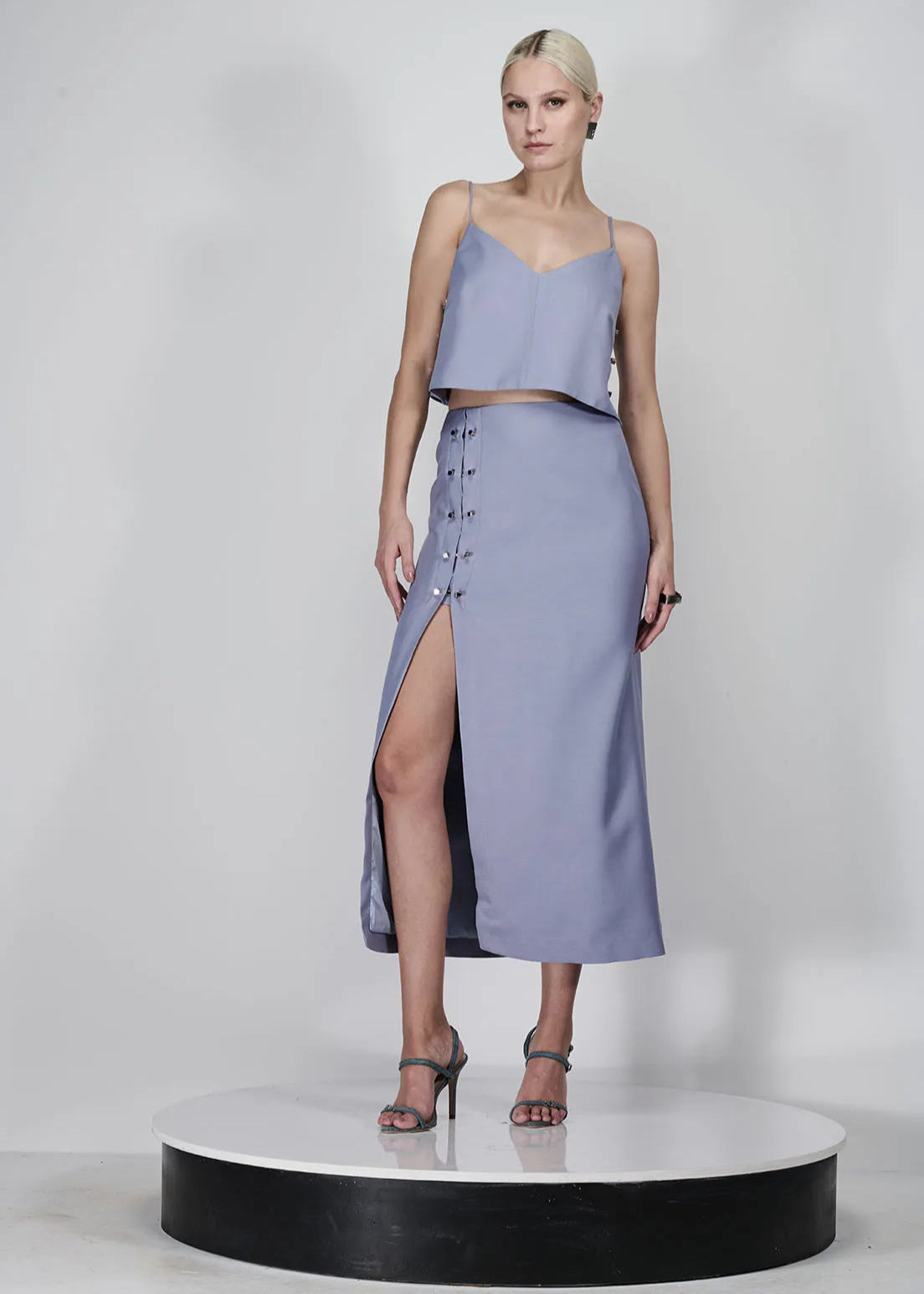 Woman wearing a light purple dress with a slit on a white background