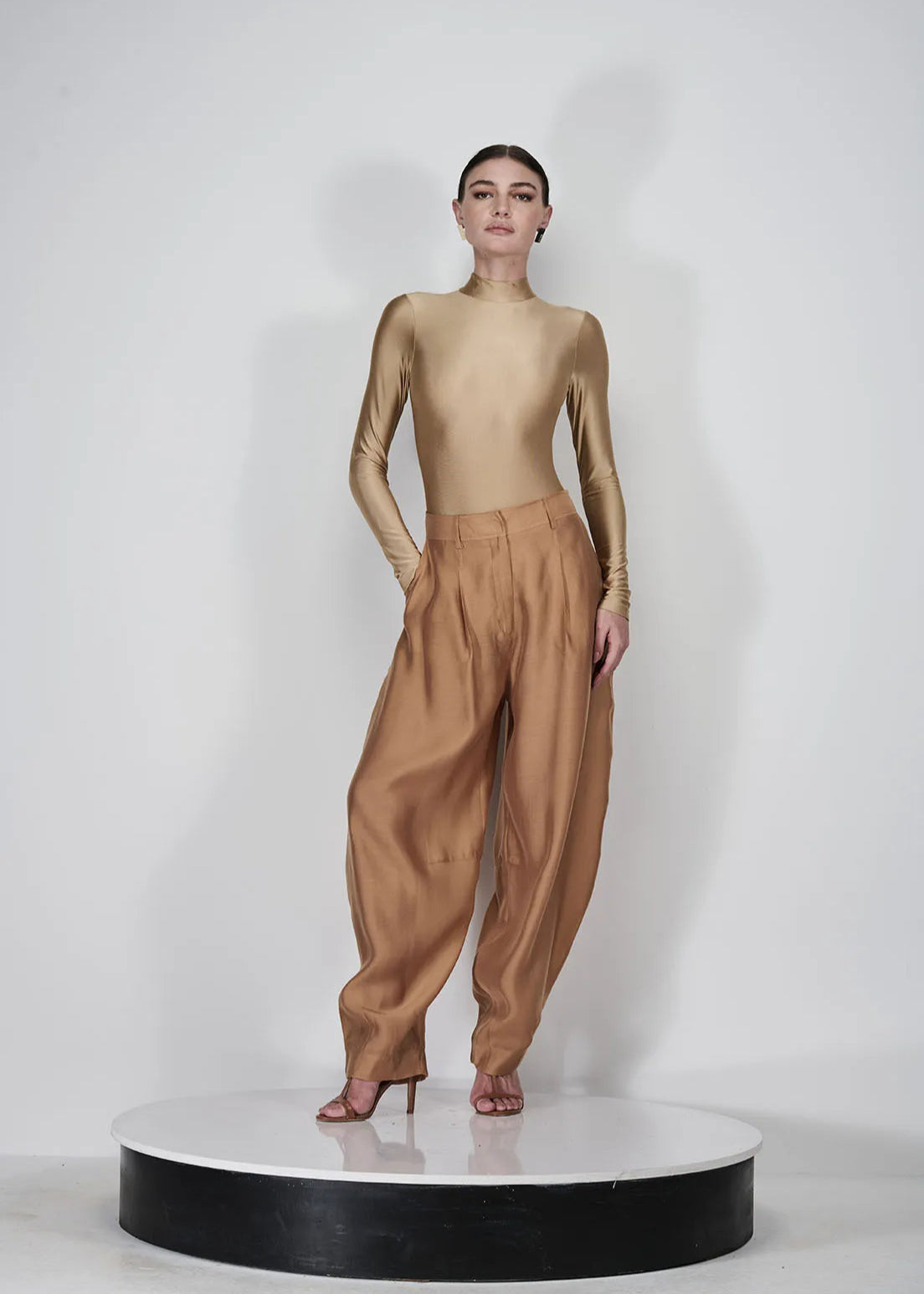 Person wearing a gold outfit on a white background