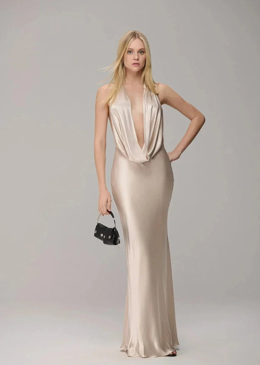 Woman wearing a gold evening gown on a plain background