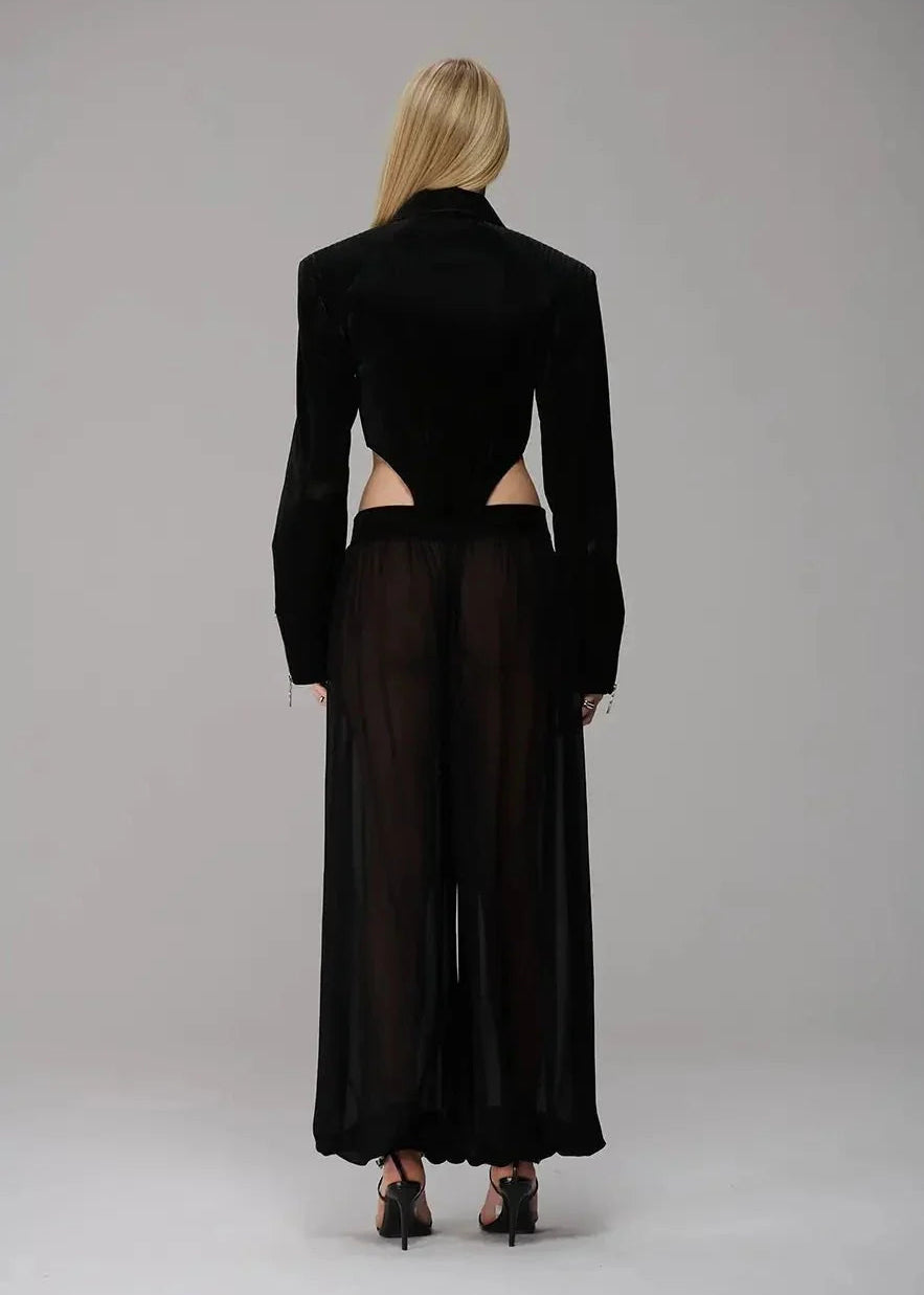 Person wearing a black cut-out dress on a gray background