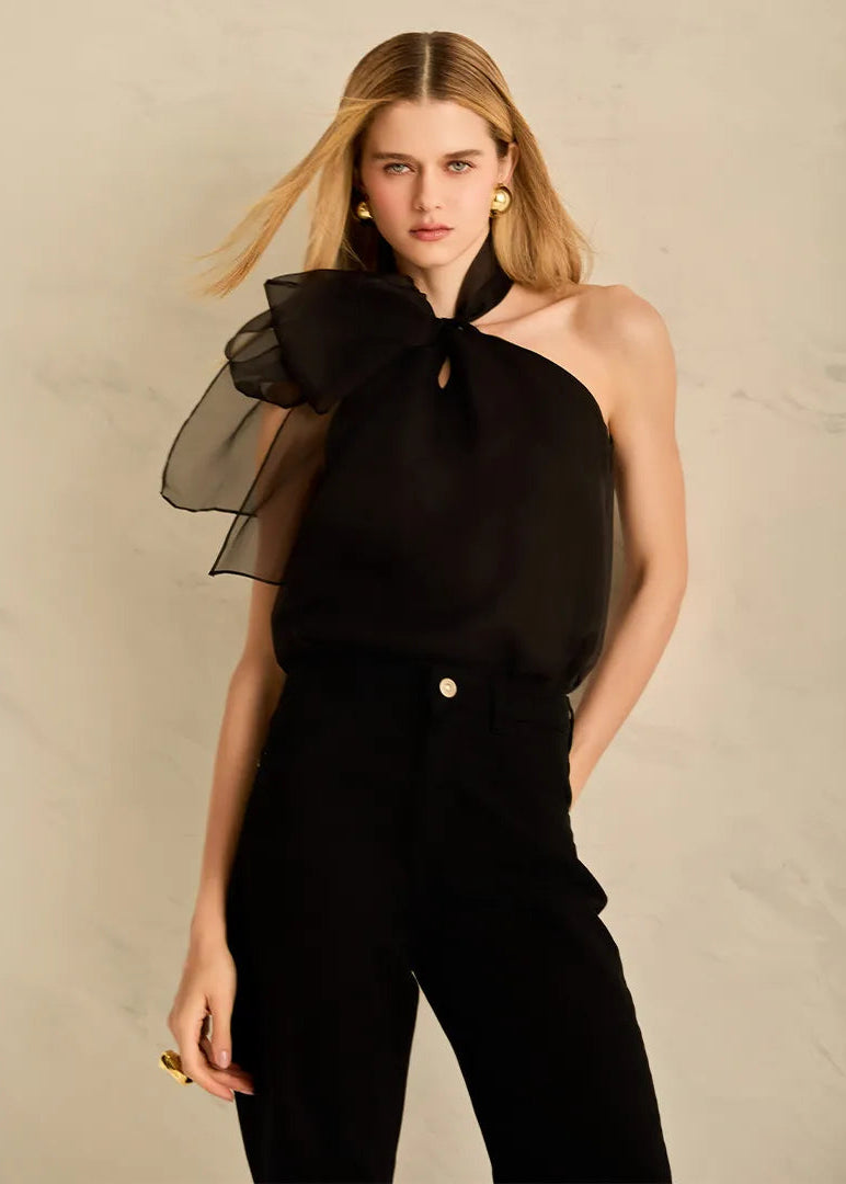 Woman wearing a black silk blouse with sheer sleeves 