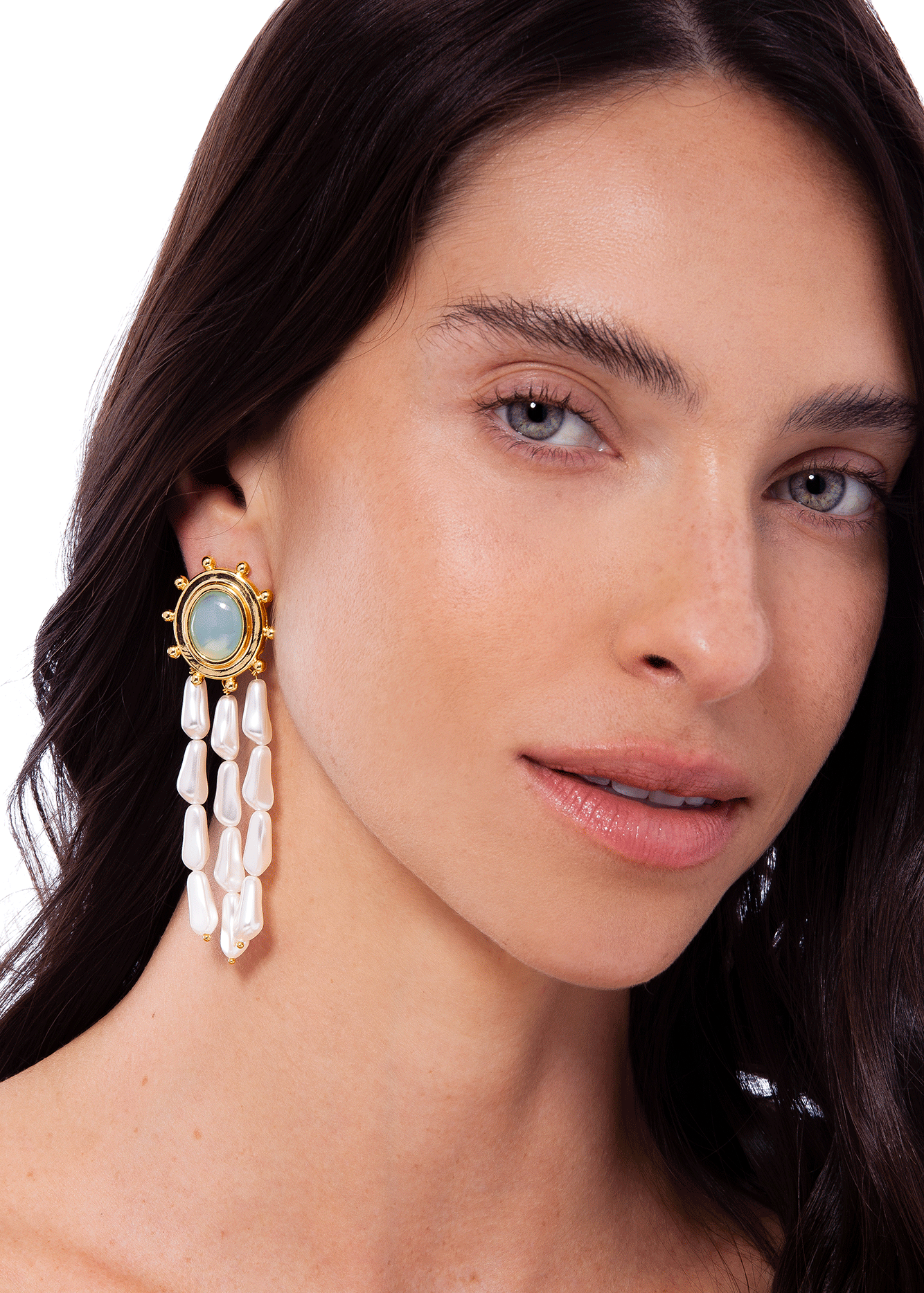 Close-up of a woman wearing a decorative earring with a white background