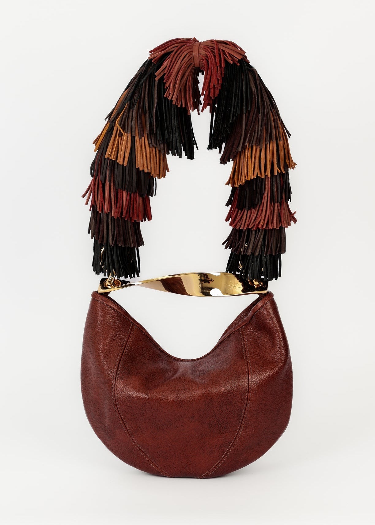 Brown leather handbag with colorful fringe on a white background