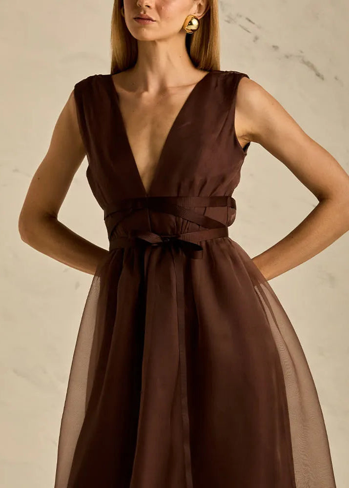 Woman wearing a brown dress with a plain background