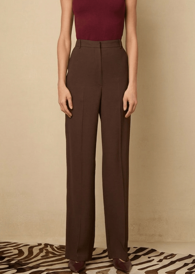 Woman wearing a burgundy top and brown pants 