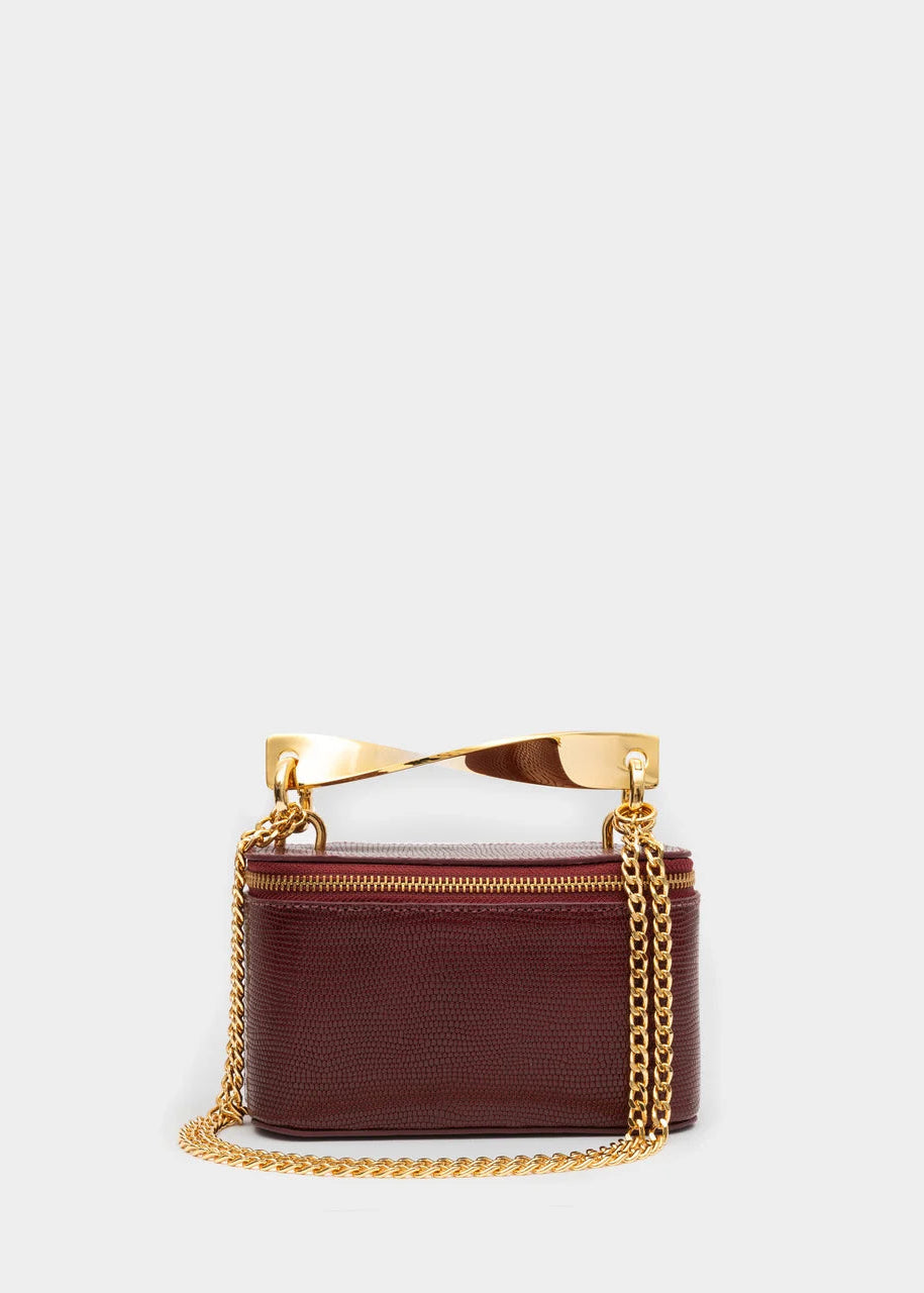 Brown handbag with gold chain and handle on a light gray background