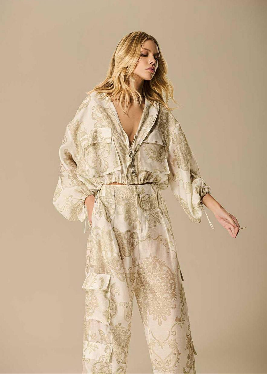 Woman wearing a floral patterned outfit against a beige background