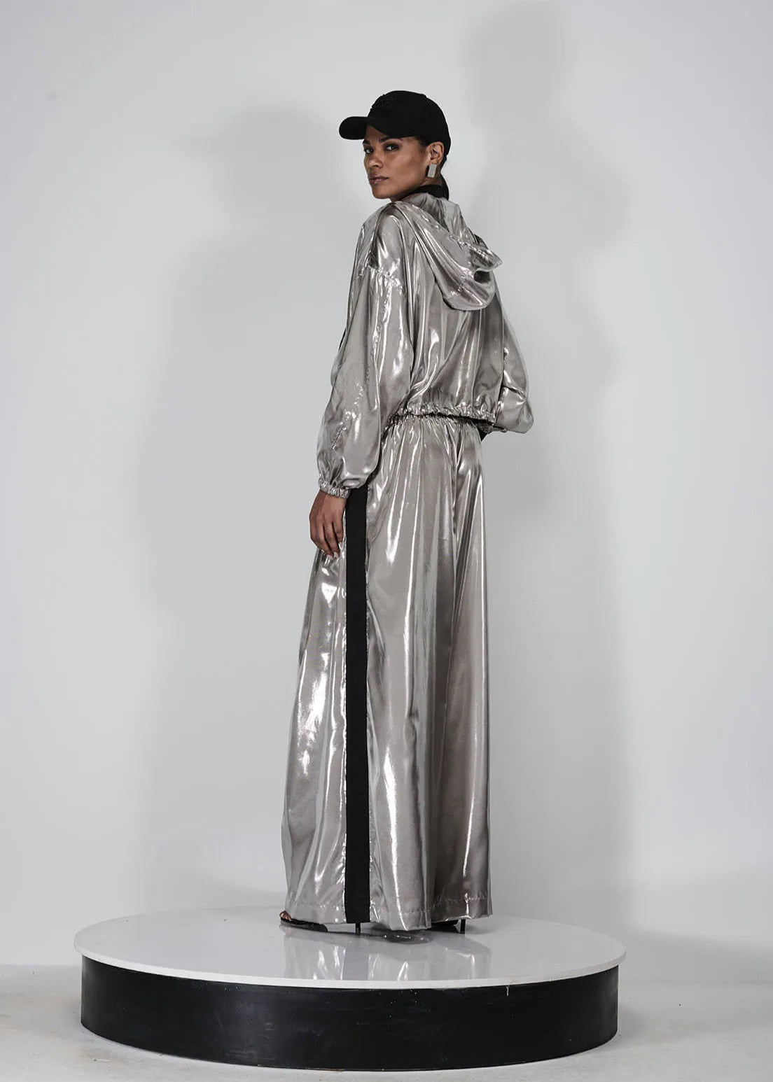 Person wearing a silver reflective outfit on a white background