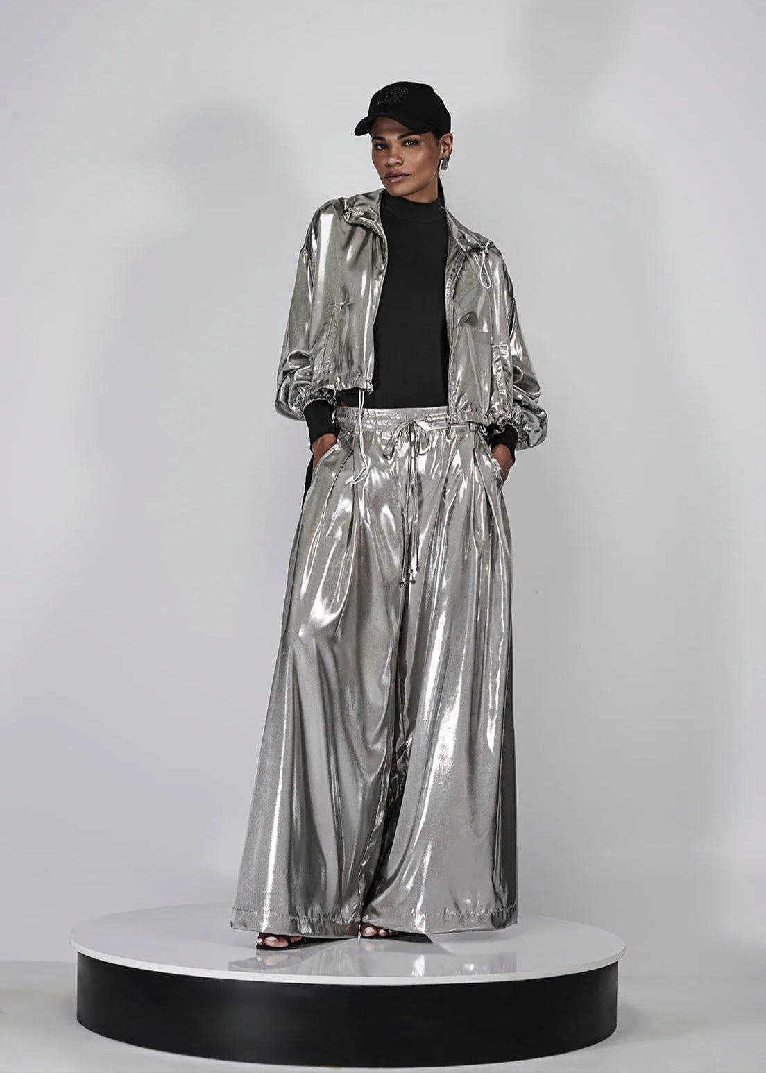 Person wearing a silver reflective outfit on a white background