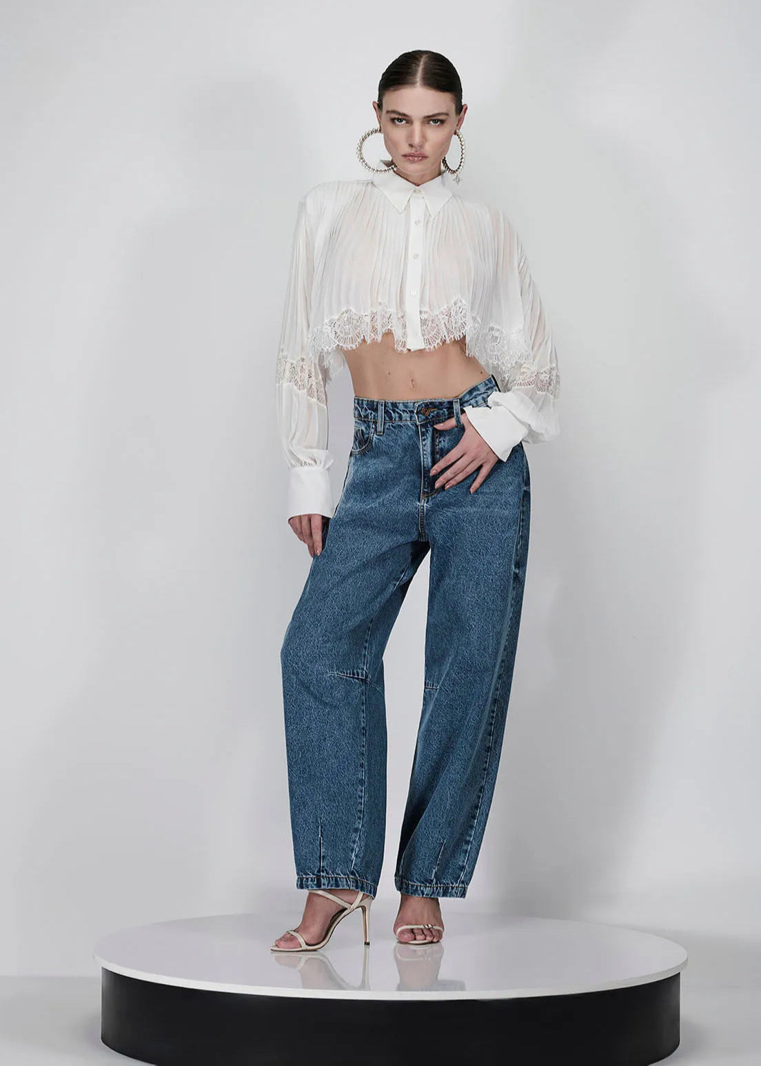Woman wearing a white blouse and blue jeans on a white background