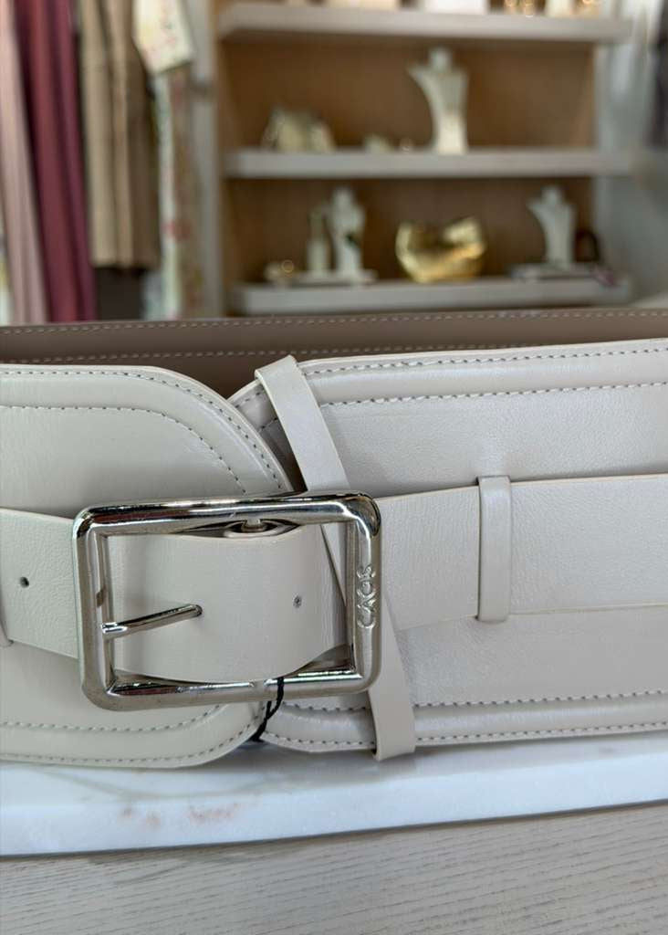 White belt with silver buckle on a light wooden surface