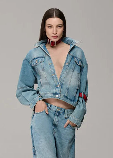 Woman wearing a blue denim outfit on a gray background