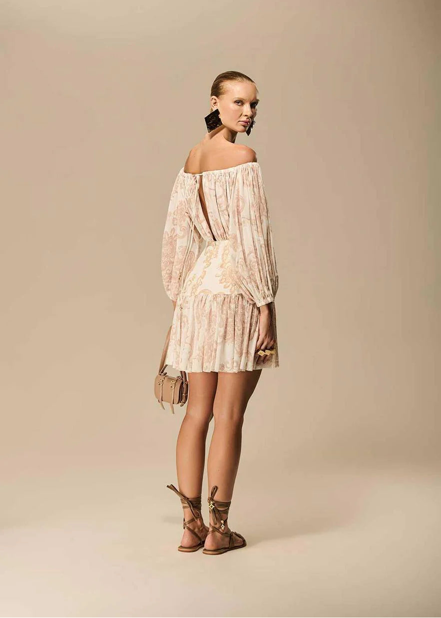 Woman wearing a beige off-shoulder dress against a beige background