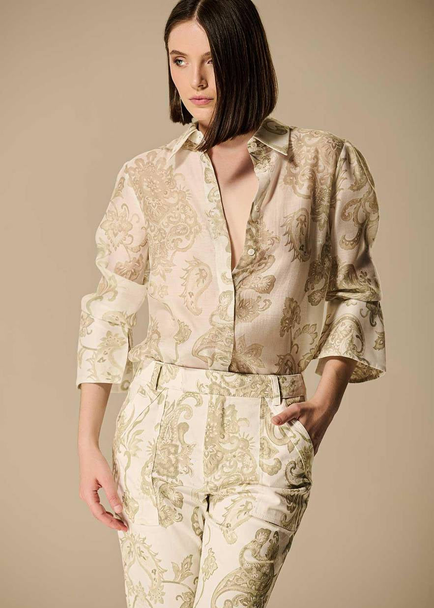 Woman wearing a patterned outfit on a beige background