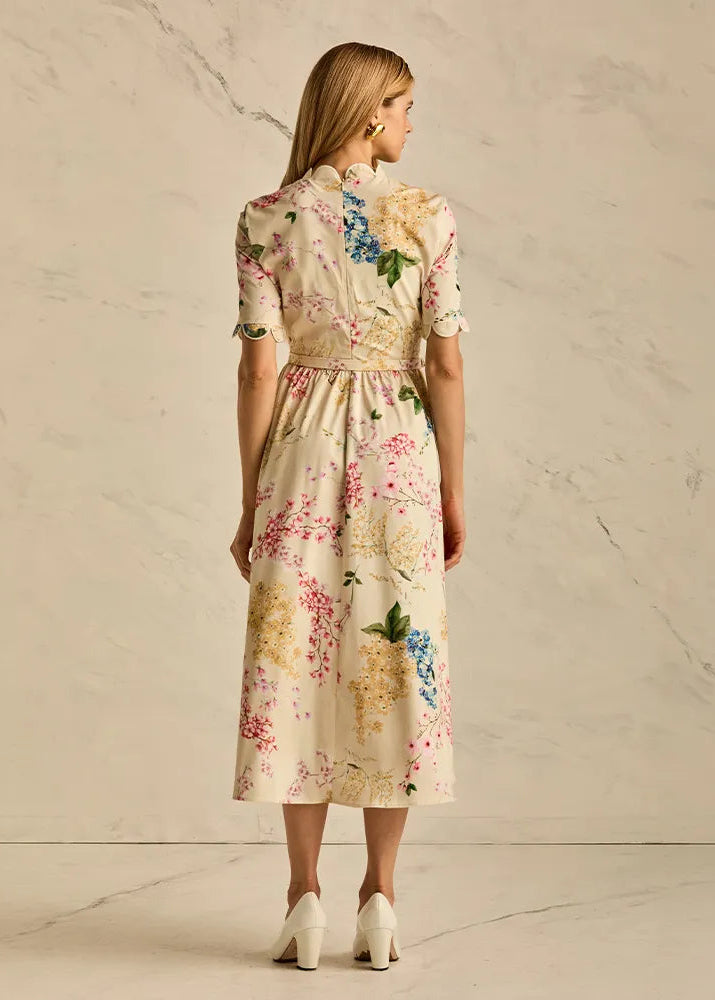 Woman wearing a floral dress against a neutral background