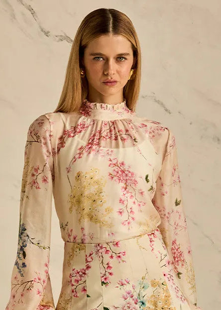 Woman wearing a floral blouse against a marble background