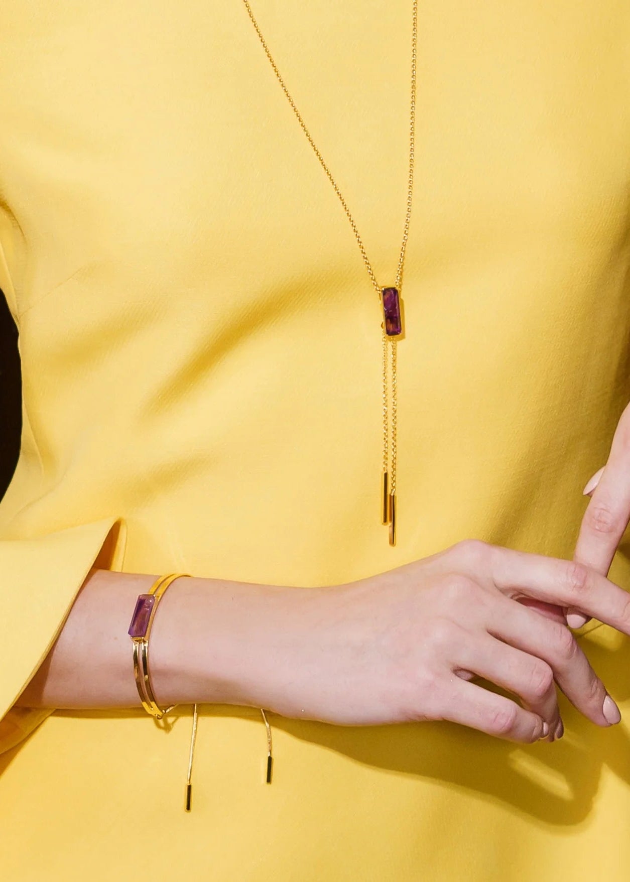 Person wearing gold jewelry with a yellow garment