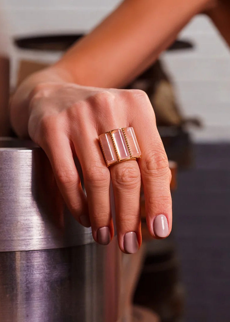 Hand wearing a rose gold ring on a blurred background