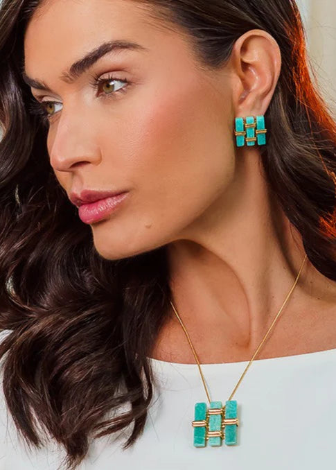 Woman wearing turquoise earrings and necklace with a blurred background