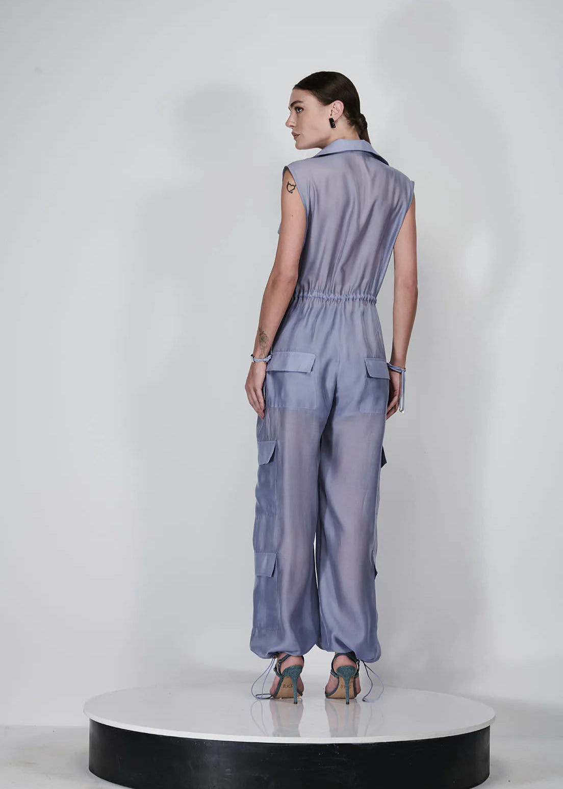 Woman wearing a light blue jumpsuit on a white background