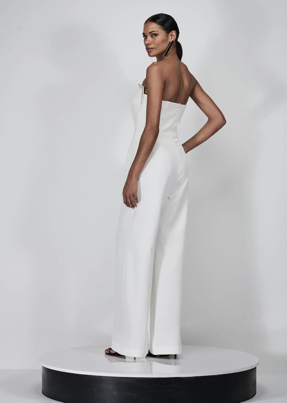Woman wearing a white strapless dress on a white background