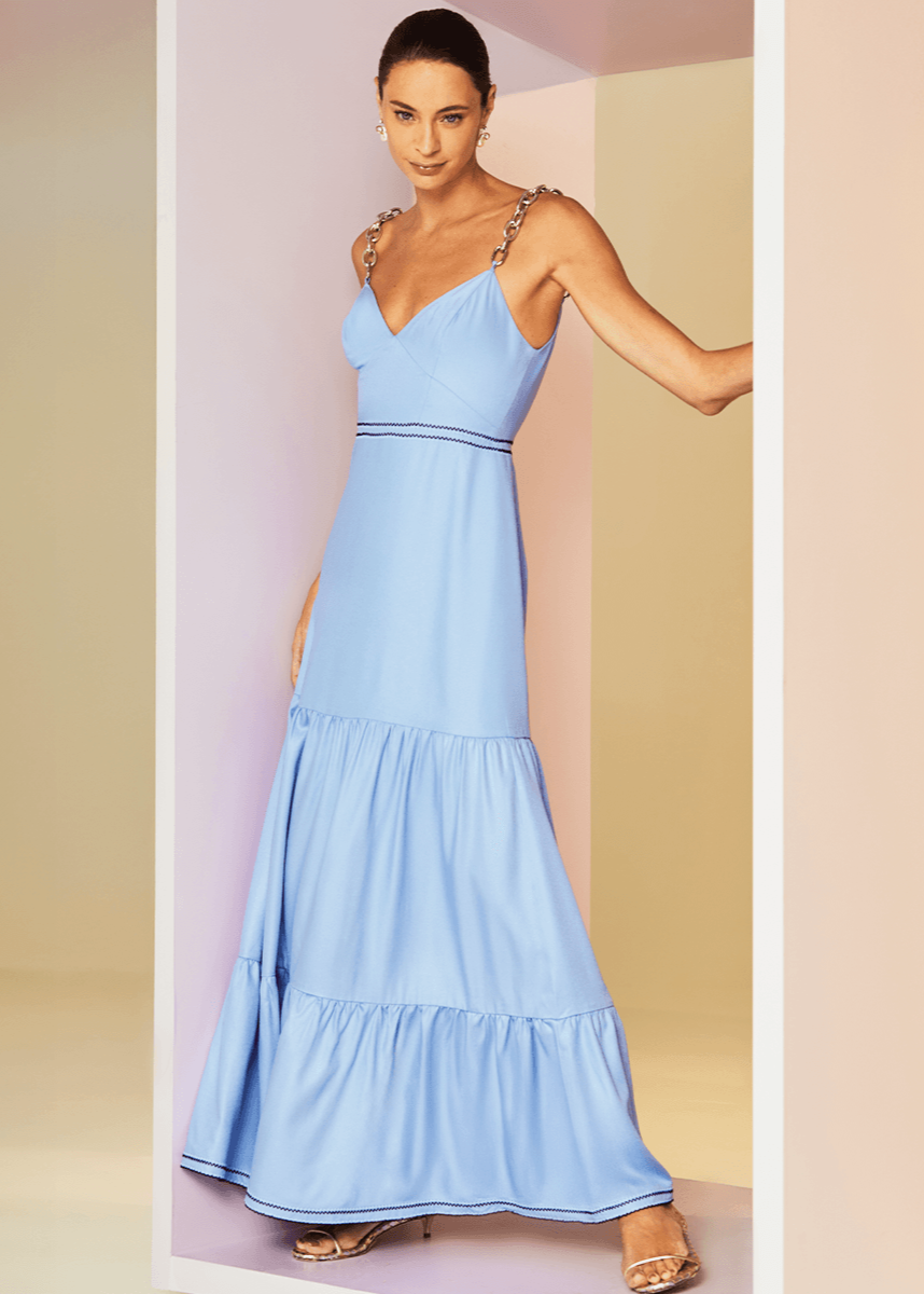 Woman wearing a light blue dress against a pastel background
