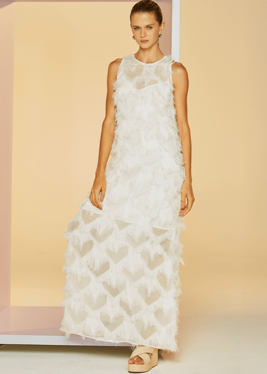 Woman wearing a white lace dress against a beige background
