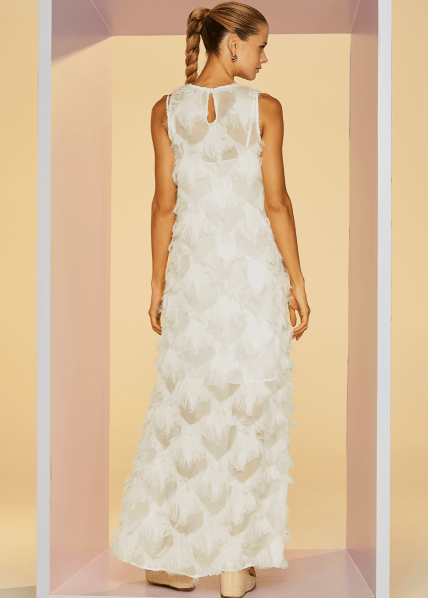 Woman wearing a white lace dress in a pastel-colored room