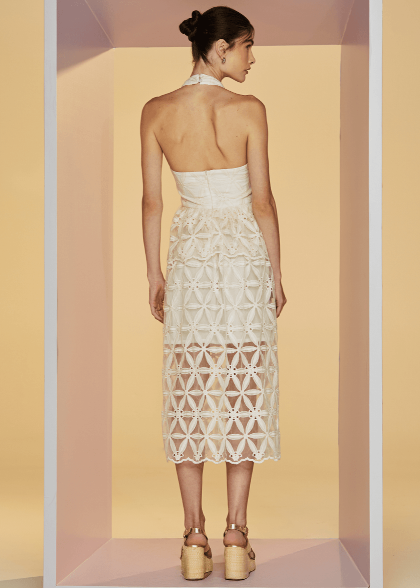 Woman wearing a white lace dress in a minimalistic setting