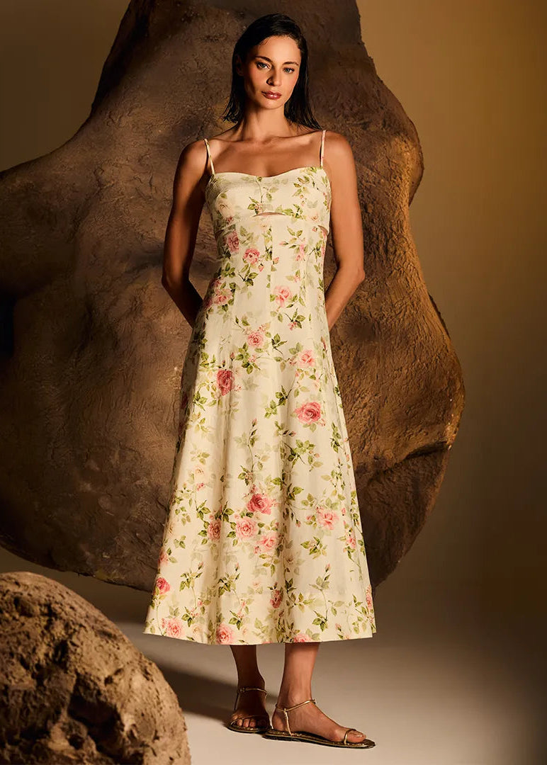 Woman in a floral dress standing against a textured brown background