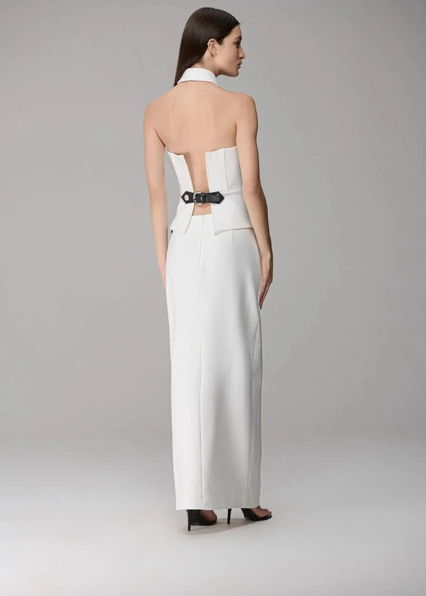 Woman wearing a white strapless dress with cut-out back on a gray background
