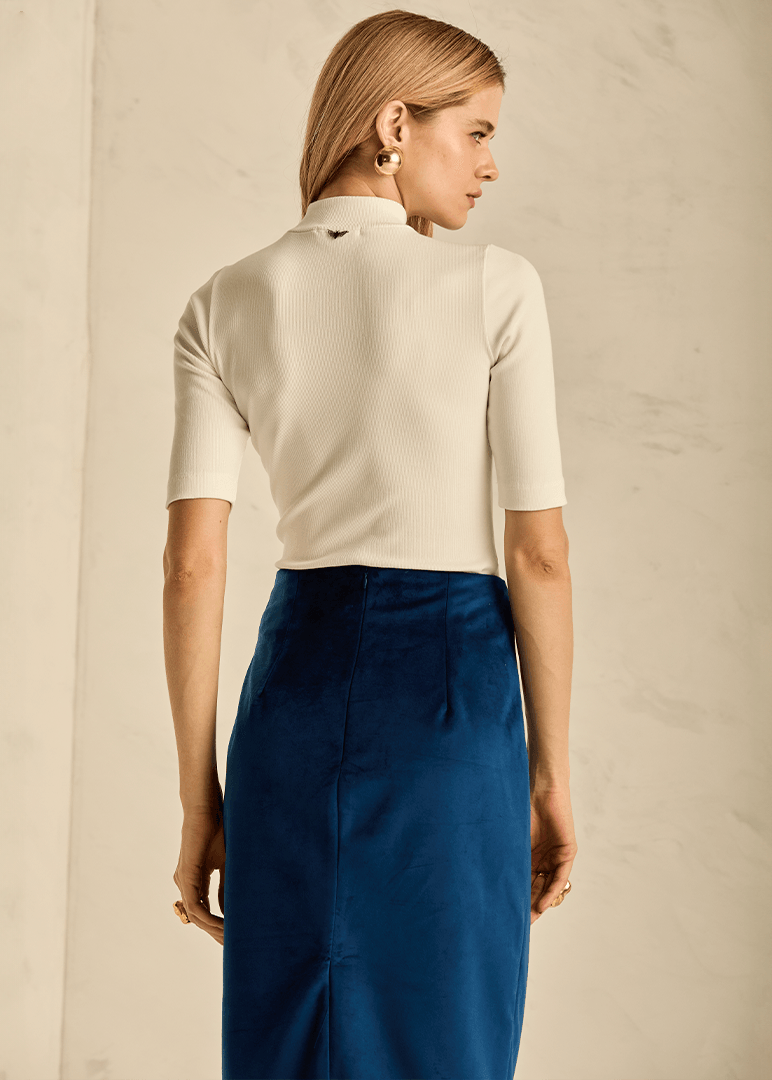 Woman wearing a white blouse and blue skirt 