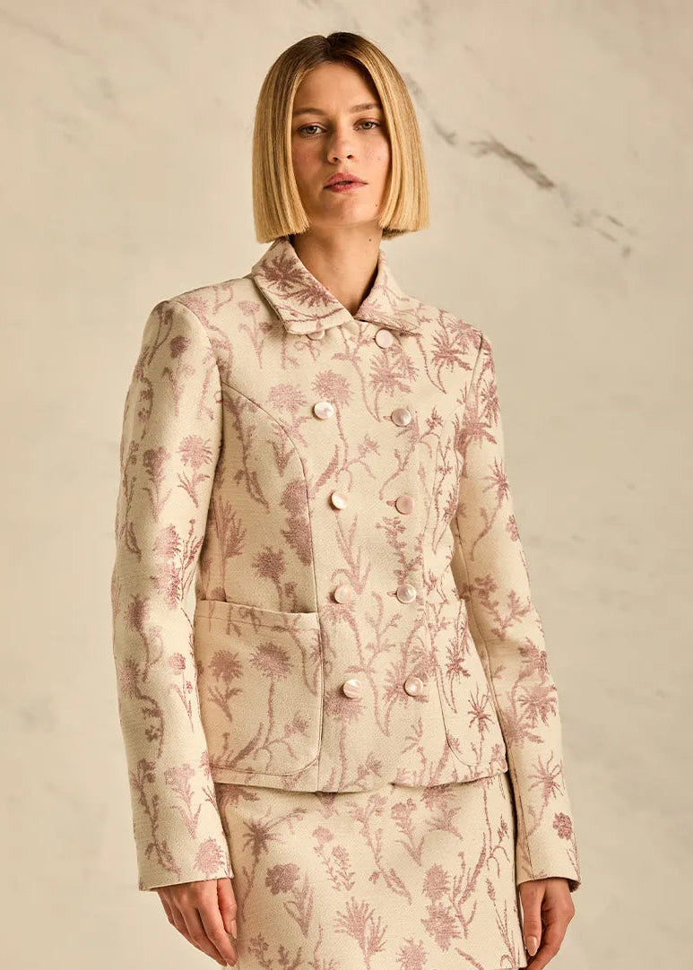 Woman wearing a floral two-piece suit against a neutral background