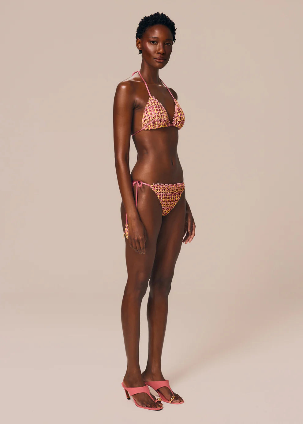 Woman wearing a crochet bikini set on a beige background
