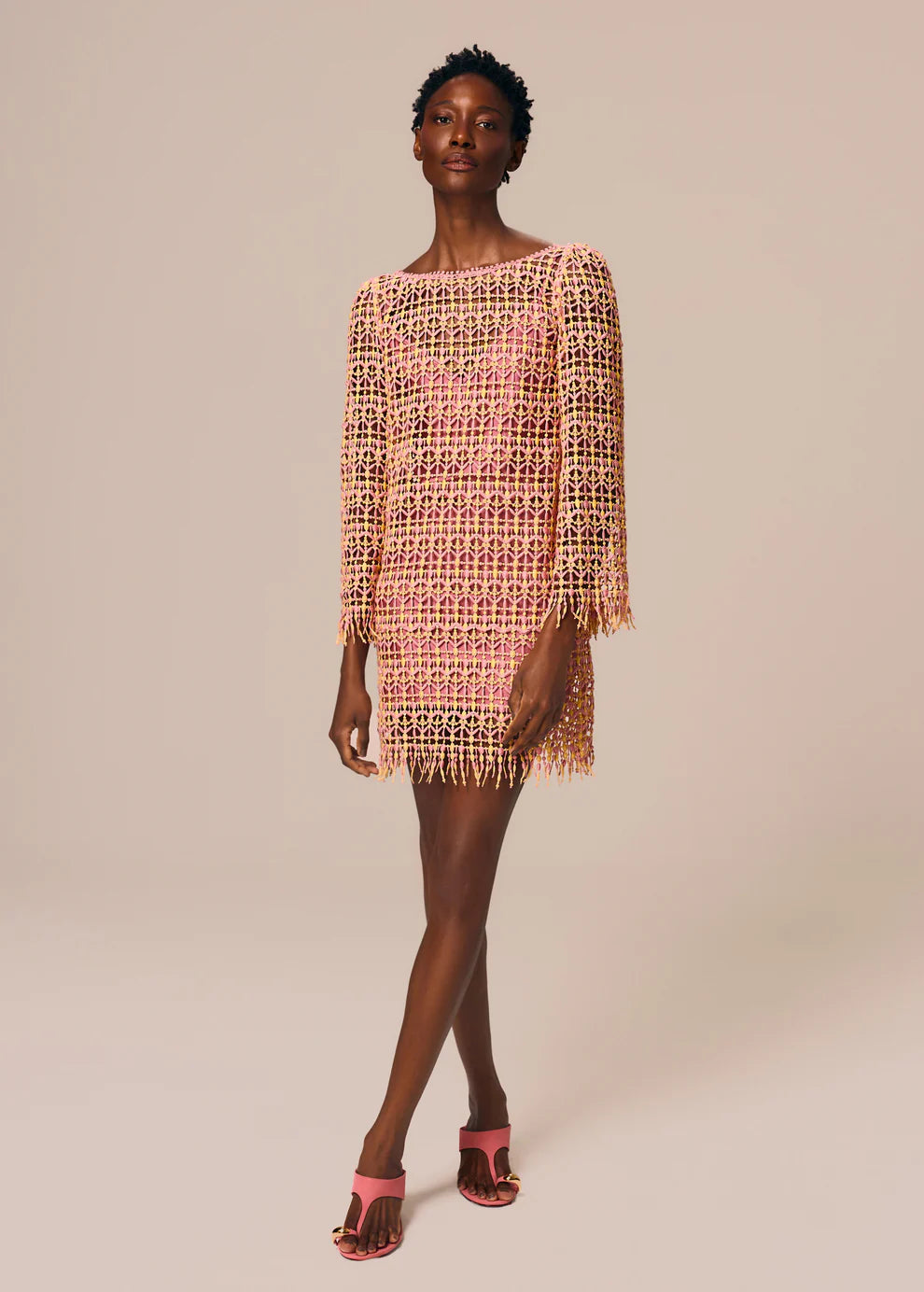 Woman wearing a patterned dress on a beige background