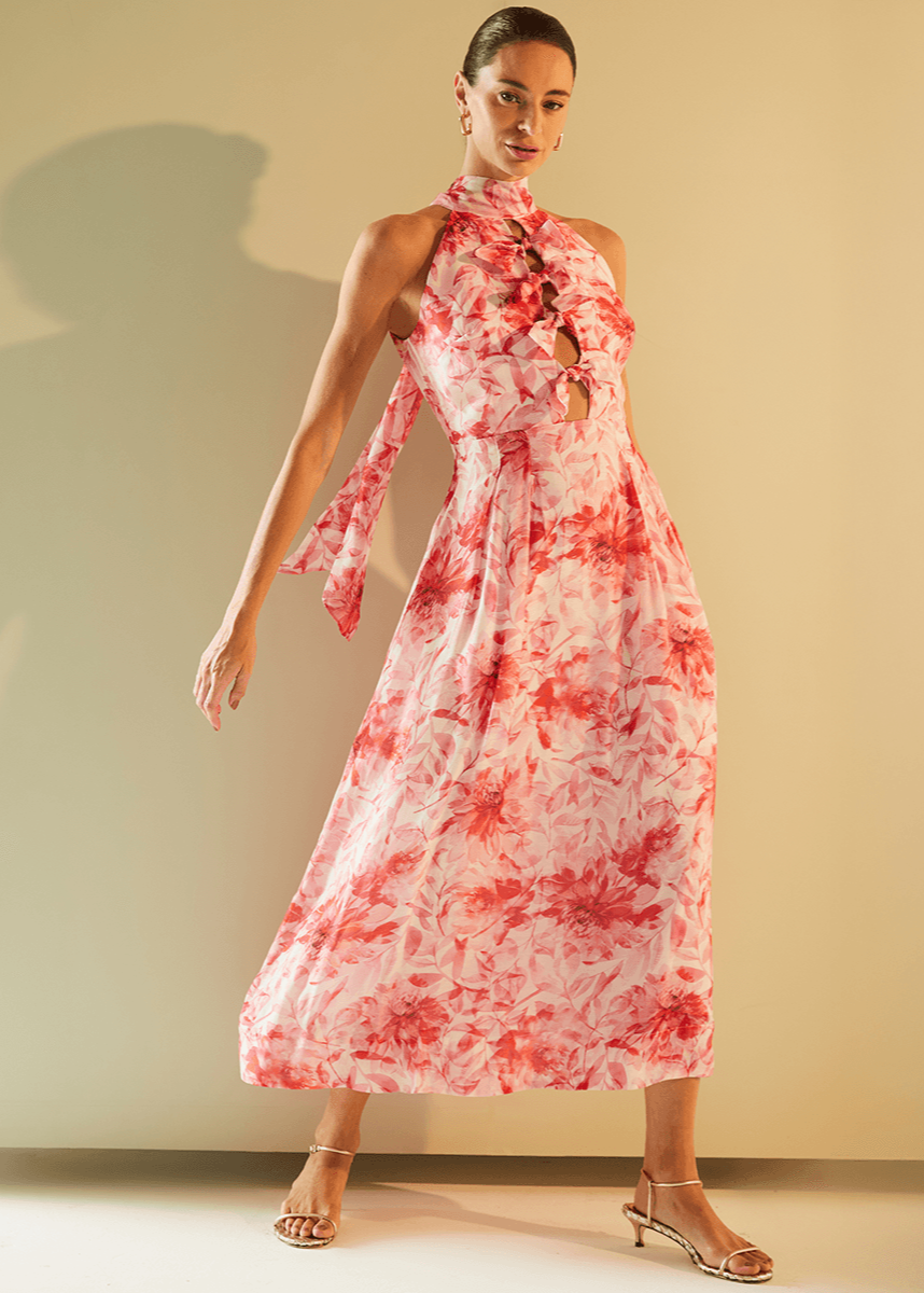 Woman wearing a red and white floral dress against a plain background