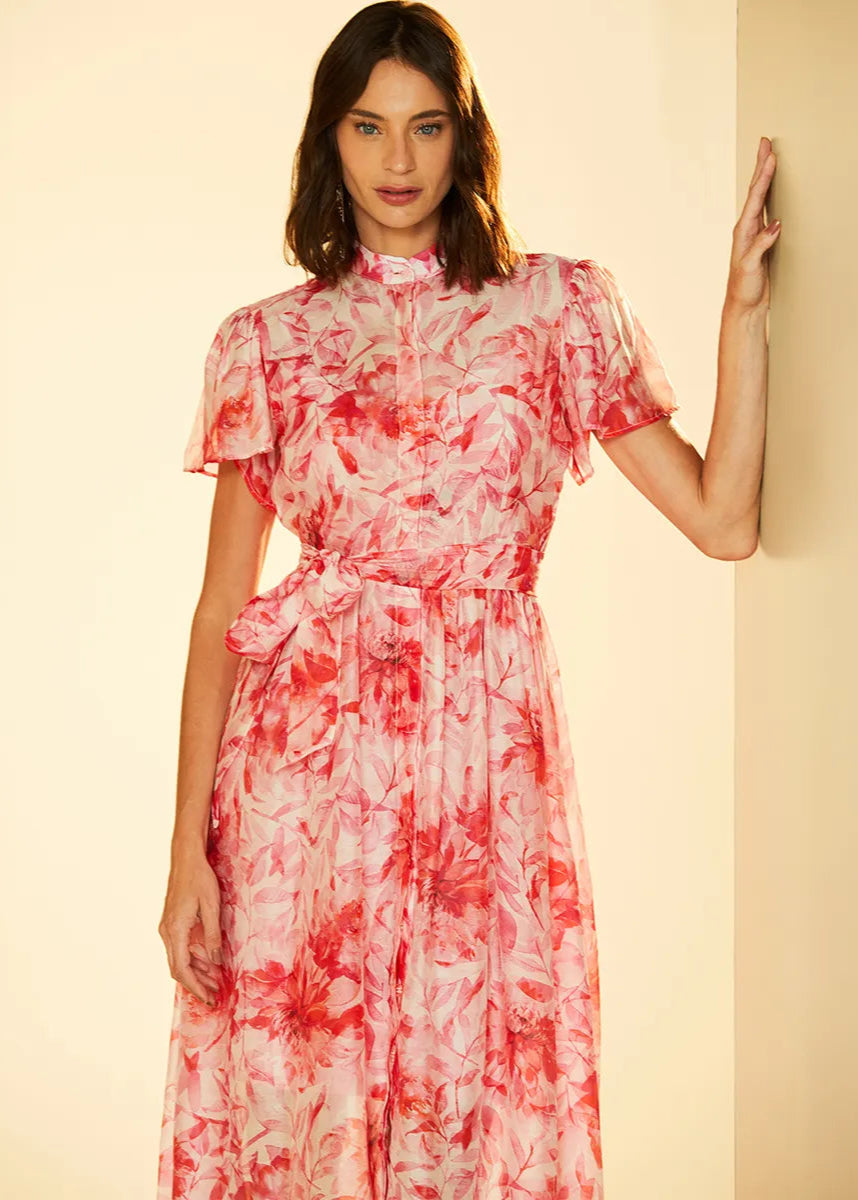 Woman wearing a red floral dress against a beige background