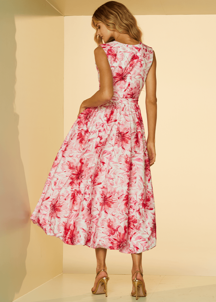 Woman wearing a red and white floral dress against a beige background