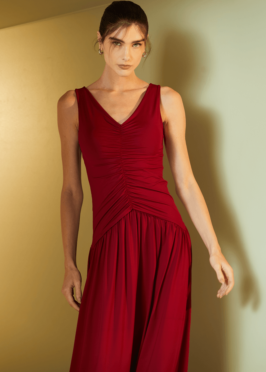 Woman wearing a red dress against a gold wall