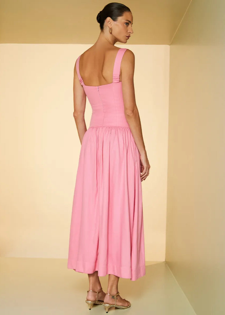 Woman wearing a pink dress in a minimalistic setting