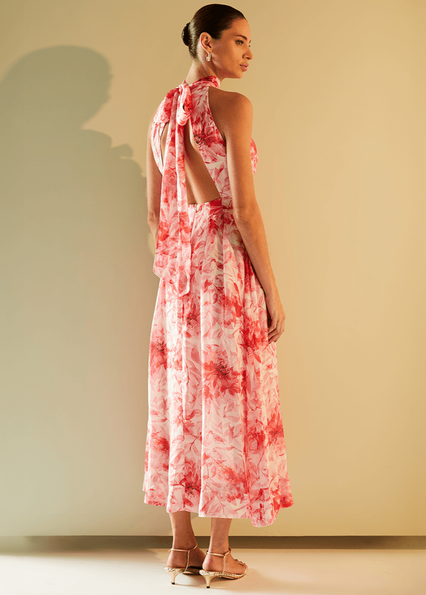 Woman wearing a red and white floral dress against a plain background