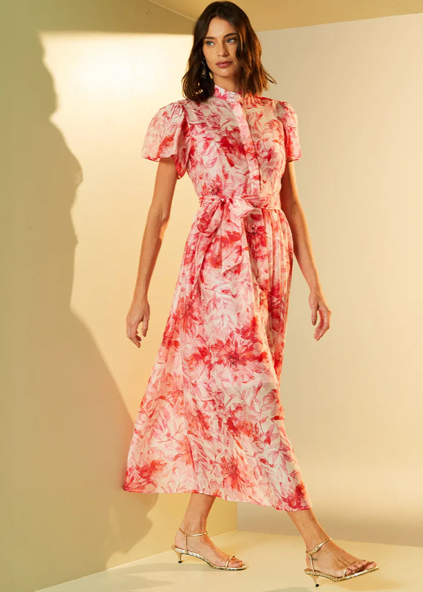 Woman wearing a red and white tie-dye dress against a neutral background