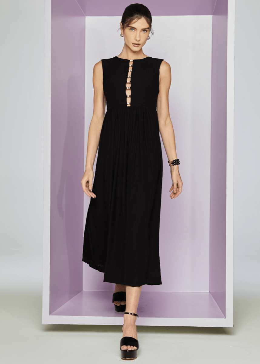 Woman wearing a black dress standing inside a white box with a purple interior.