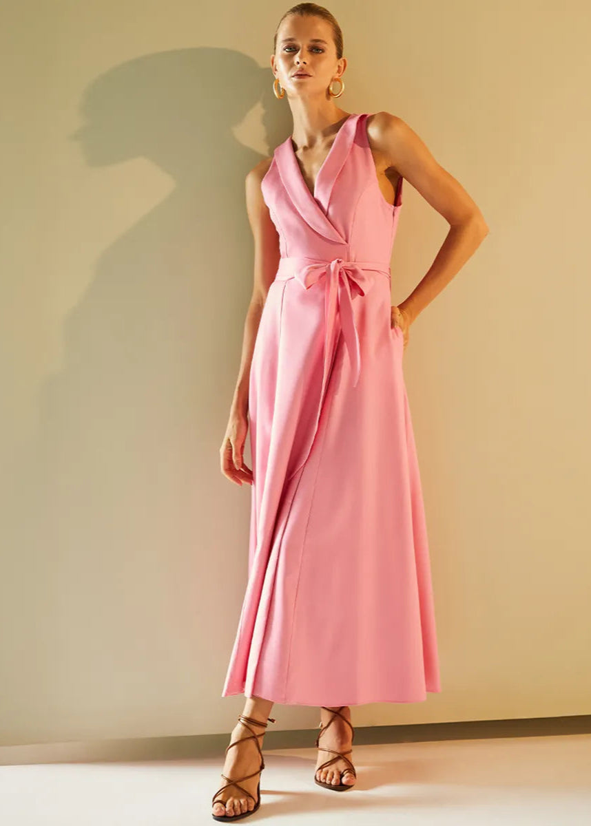 Woman wearing a pink dress against a plain background