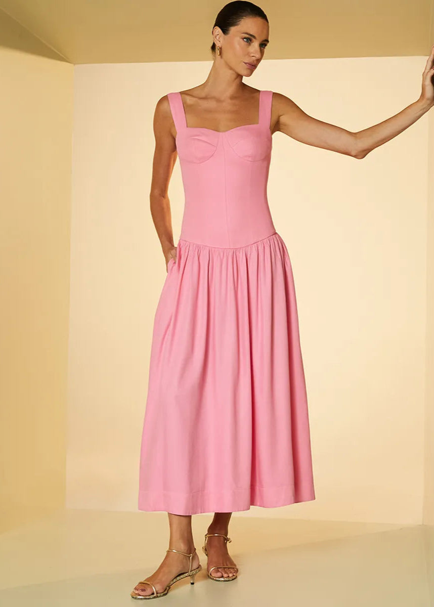 Woman wearing a pink dress against a beige background