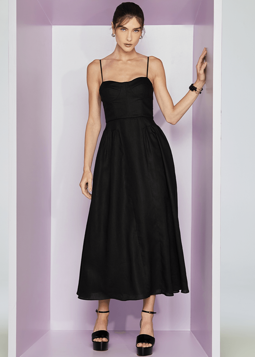 Woman wearing a black dress against a white and purple striped background